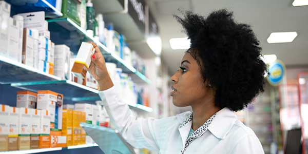 Female hospital pharmacy worker selecting medicine